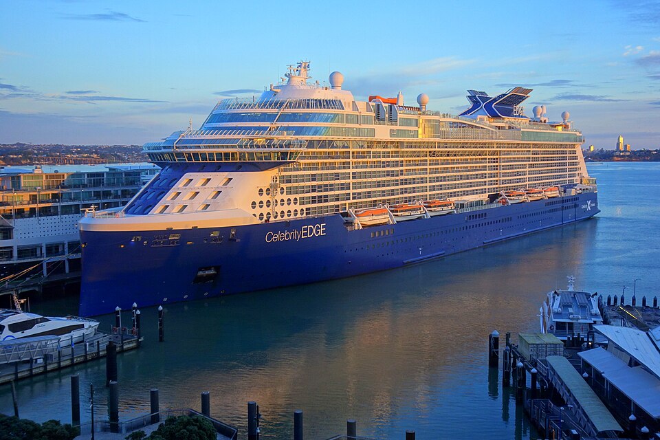 Celebrity Edge cruise ship docked at port during early evening, showing the Edge-Class vessel’s distinctive angular design