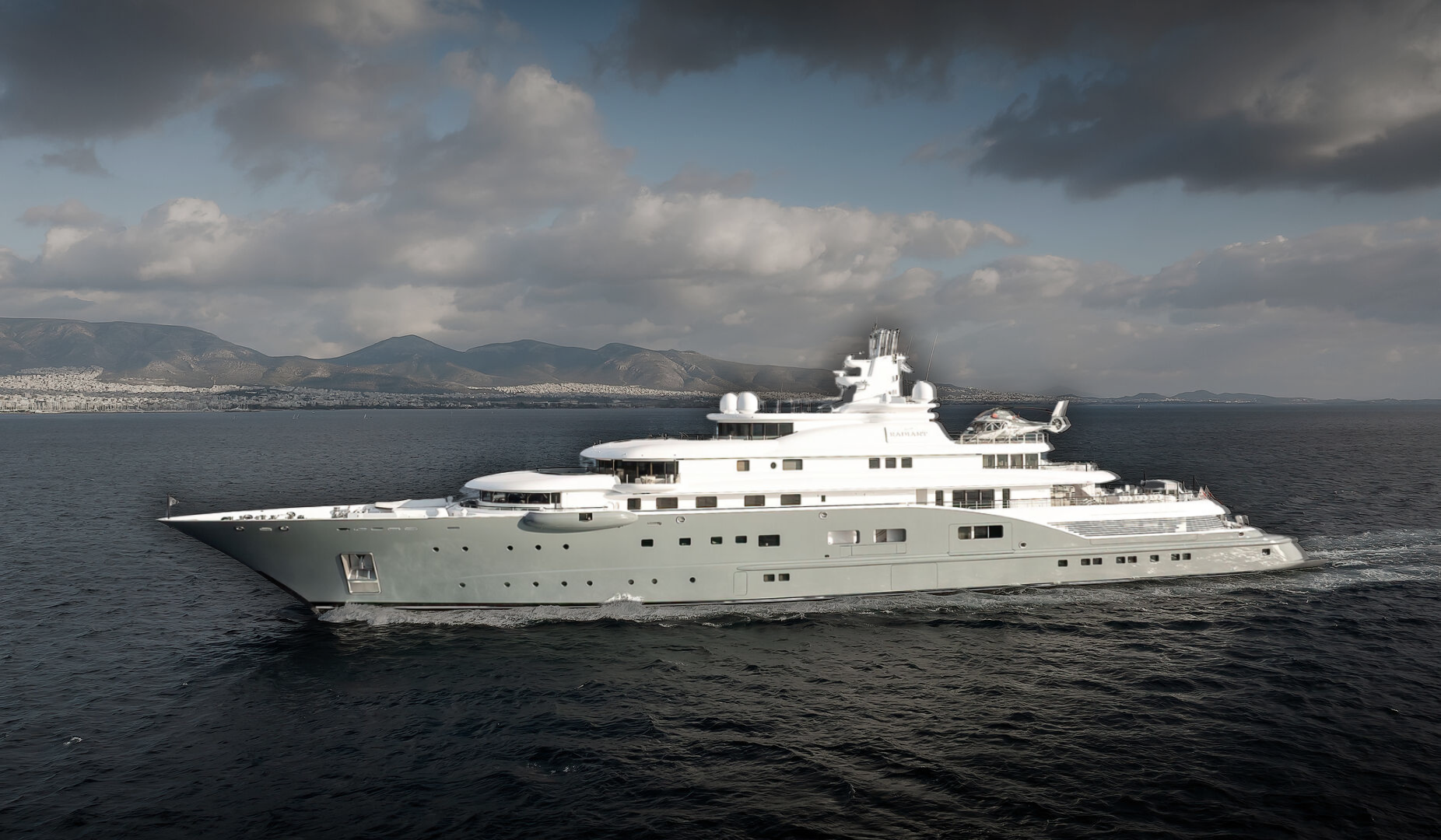 110m Lürssen superyacht Radiant cruising through the waters of Athens with mountains and cityscape in the background