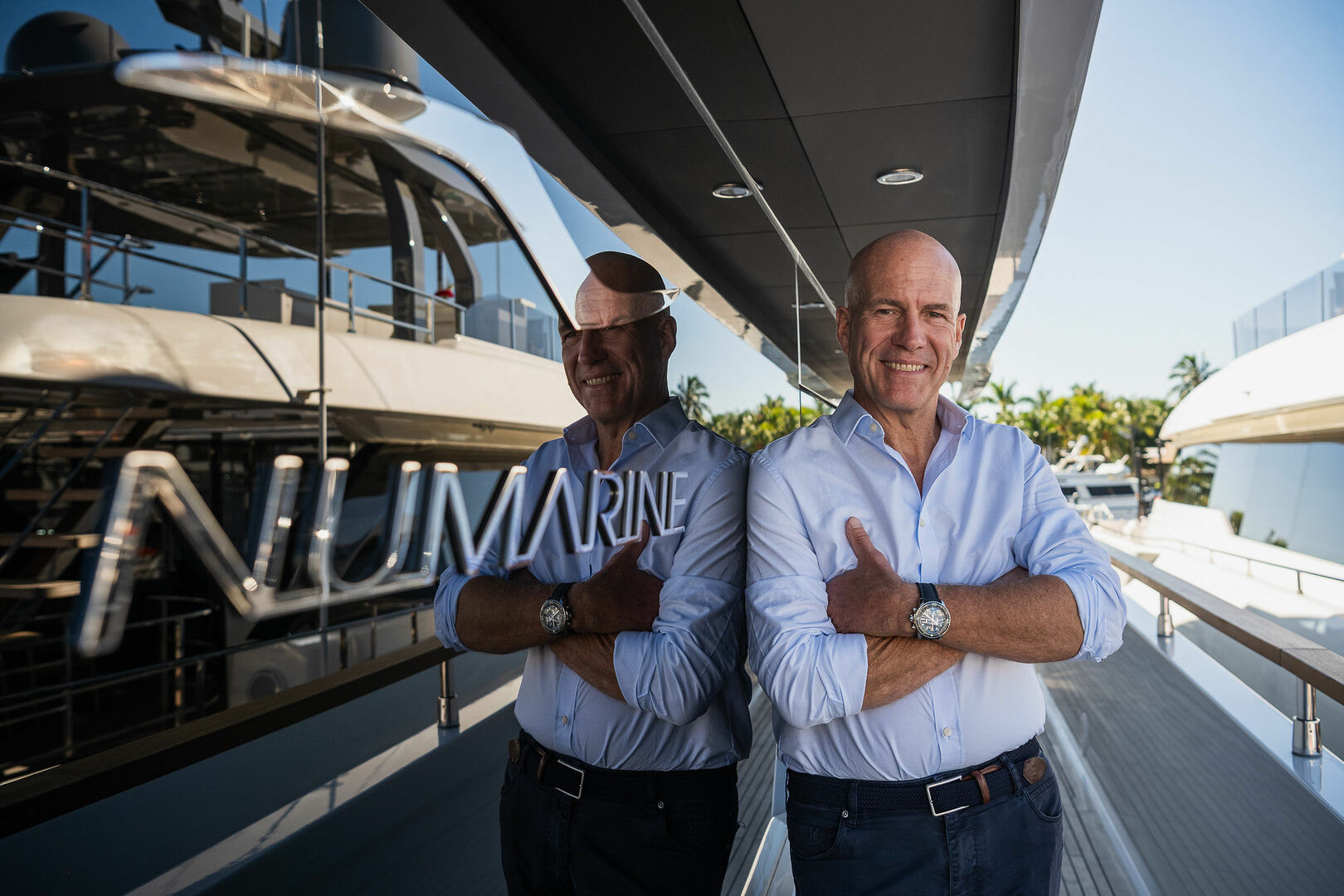 Patrik von Sydow standing on a Numarine yacht, smiling with arms crossed, reflected in the vessel’s glass panel with the Numarine logo visible