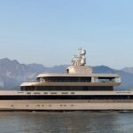 The 72-metre Admiral superyacht No Rush cruising in calm waters with mountains visible in the background